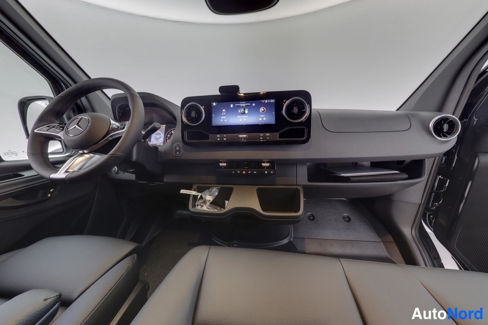 Muu: Mercedes-Benz Sprinterin ohjaamo: ohjauspyörä, infotainment-näyttö ja tummat penkit