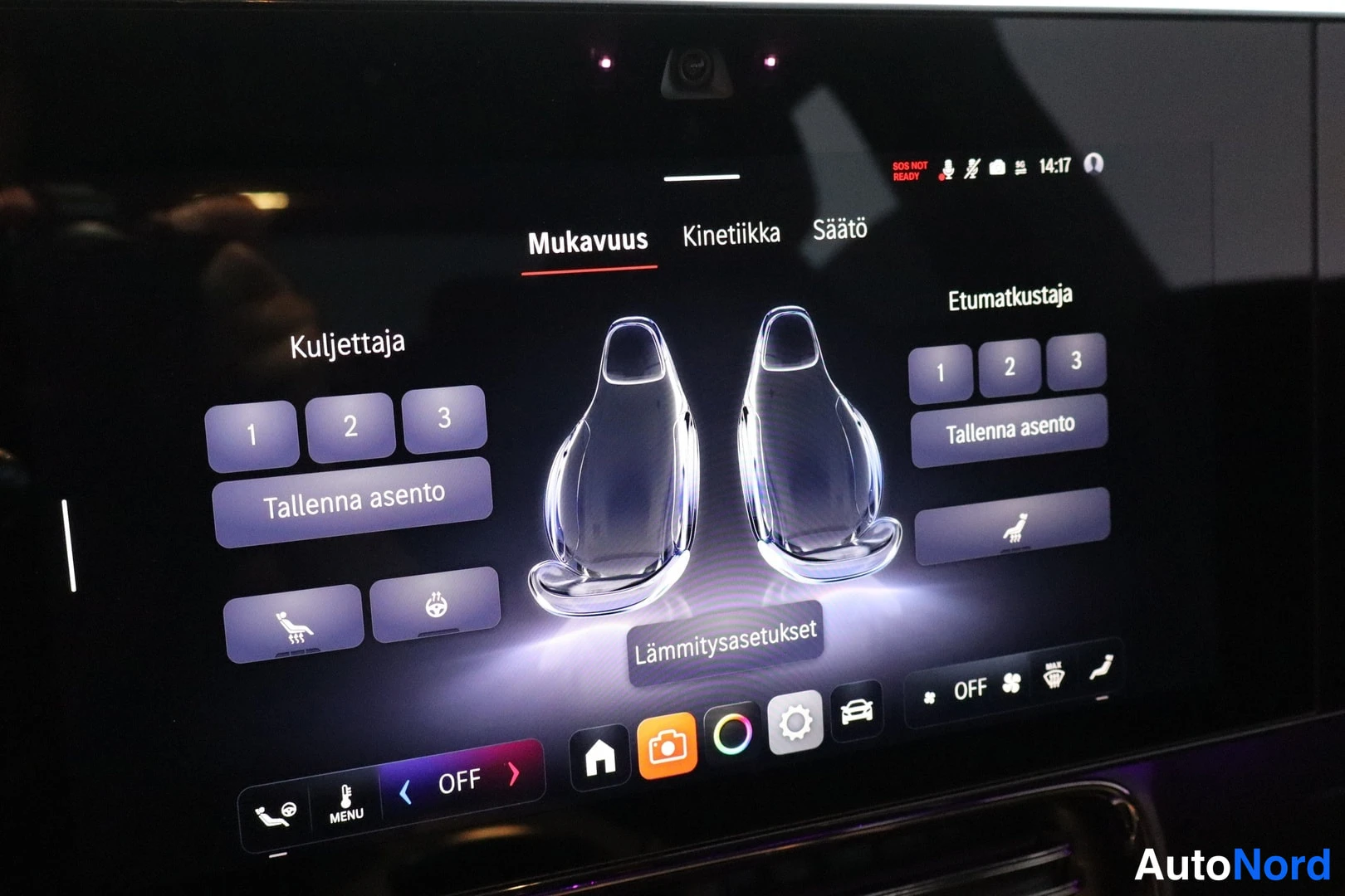 Etuviisto, nokka vasemmalle: Auton infotainment-näyttö, jossa on auki Mukavuus-valikko istuinten lämmitys- ja asetusasetuksille (Kuljettaja ja Etumatkustaja) suomeksi.