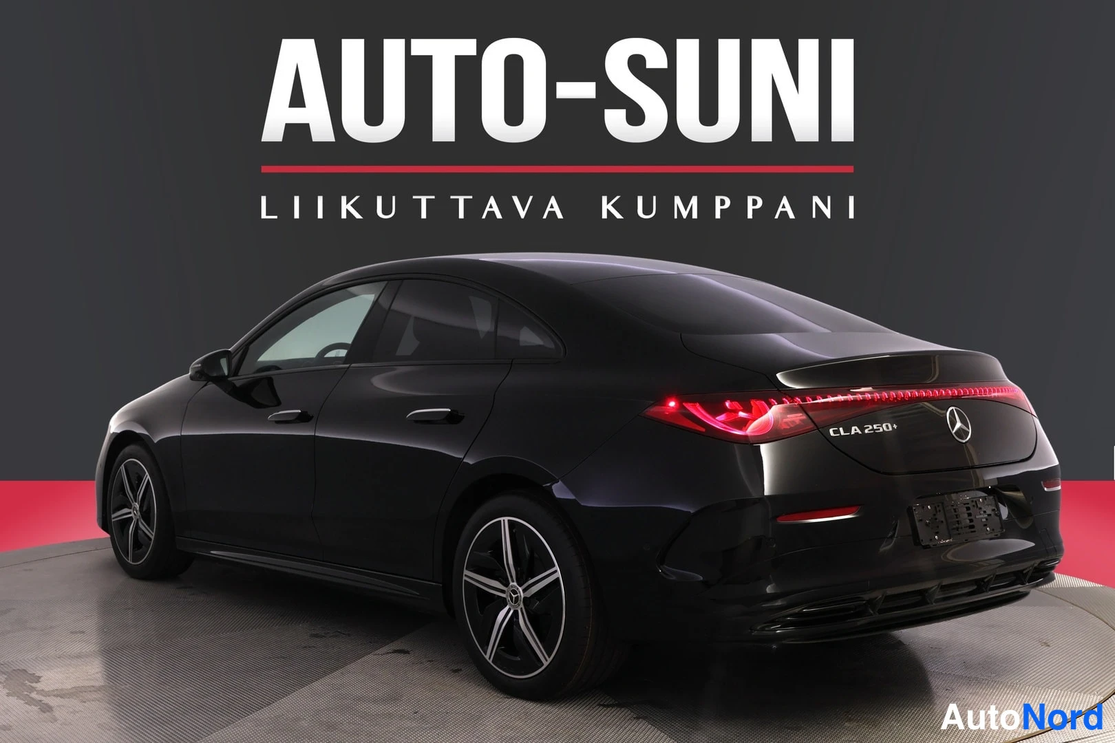 Takaviisto: Musta Mercedes-Benz CLA 250+ -henkilöauto kuvattuna takaviistosta; takavalojen valovyöhyke, takaluukki, Mercedes-tähti ja vasen kylki näkyvissä studiossa.