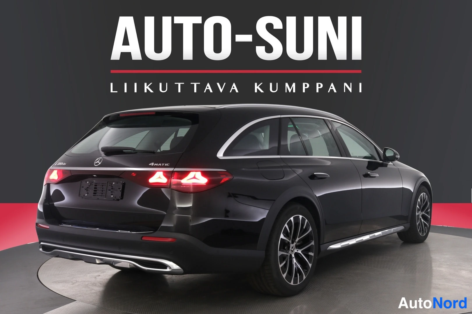 Takaviisto: Musta Mercedes-Benz farmari takaviistosta, takavalot syttyneinä, 4MATIC-teksti takaovessa.