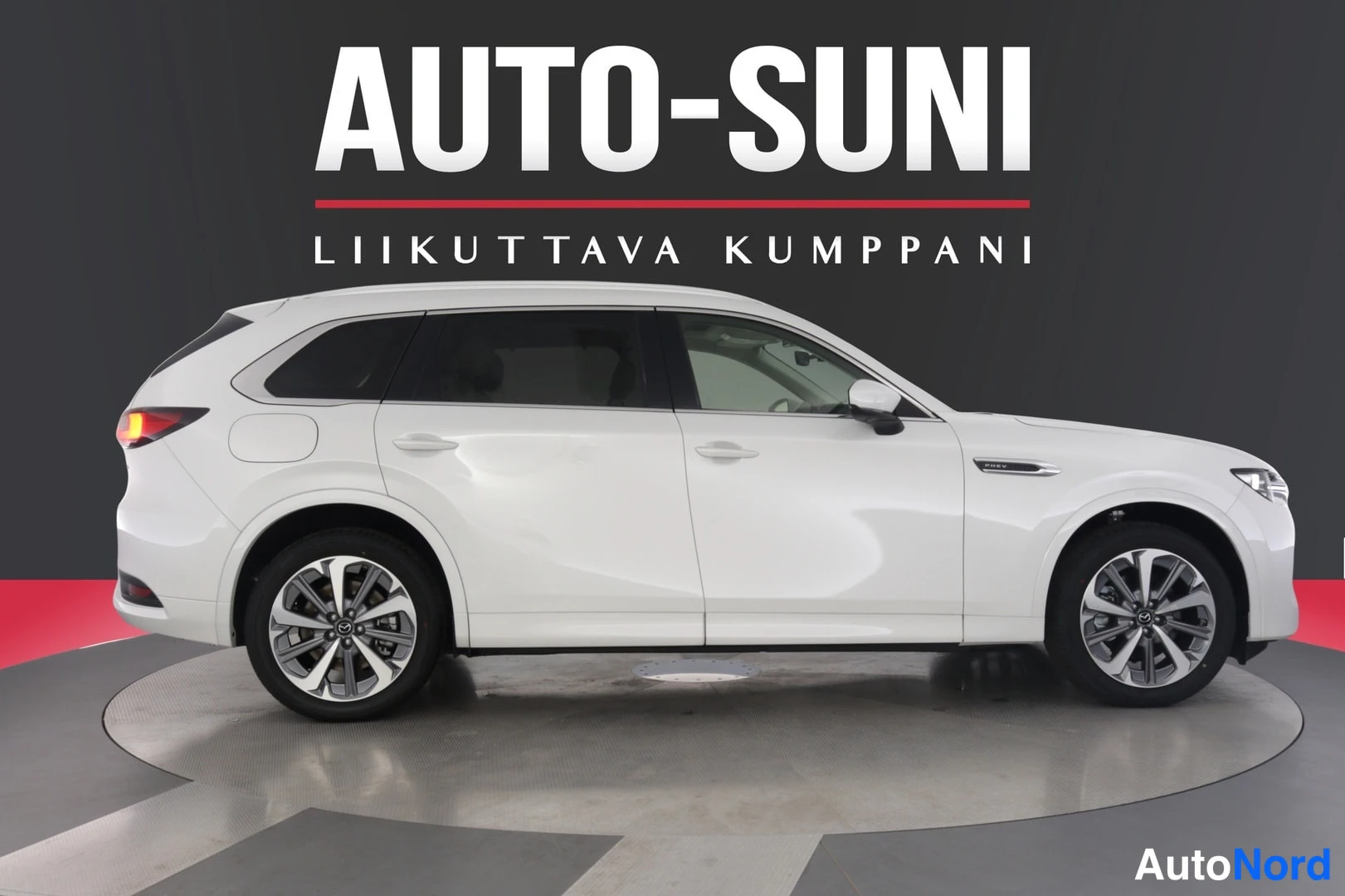 Sivulta: White SUV shown in full side profile on a rotating platform against a dark studio wall with 'AUTO-SUNI' text.