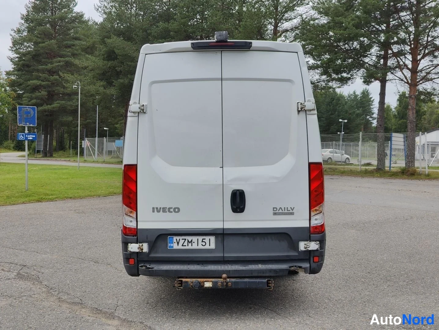 Takaa: Iveco Daily -kuorma-auto näkyy suoraan perästä. Kaksiovisessa takaosassa lukee vasemmalla IVECO ja oikealla DAILY. Autoon kuuluu kytkinperävaunun vetokouku ja r
