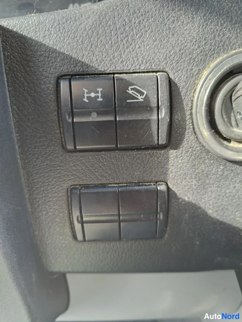 Yksityiskohta: Dashboard-painikkeen sarja; painikkeet ovat hihhuloidun muotoisia. Yläosassa vasemman puolen painiketta on H-muotoinen symboli, oikealla oleva painike on ikkuna