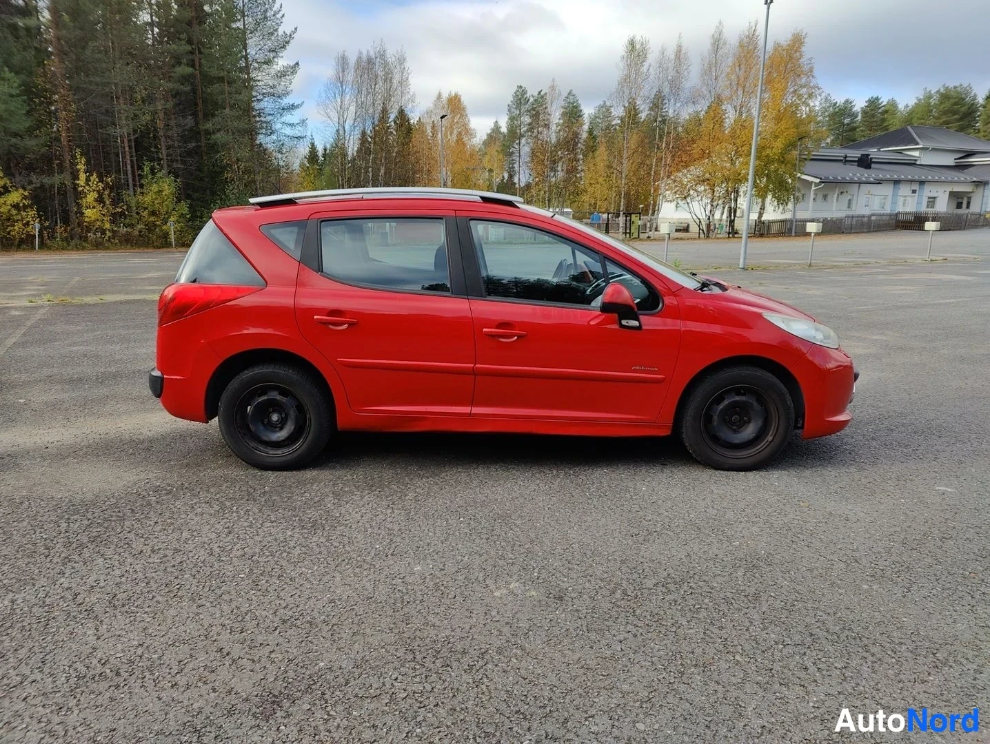 Sivulta: Right profile shot of a red hatchback parked on asphalt.