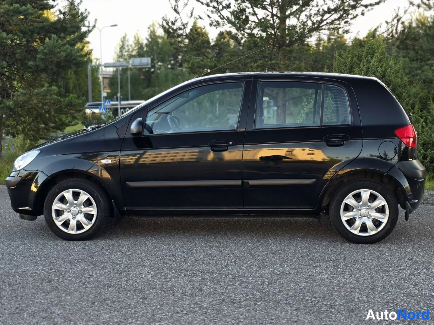 Sivulta: Suvien musta Hyundai Getz sivusta. Koko auton profiili näkyy, mukaan lukien alumiinivanteet ja ovenkahvat