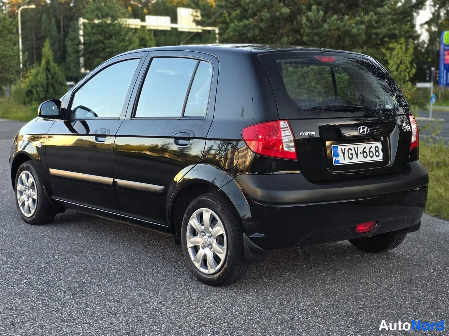 Takaviisto: Takana kolmen neljänneksen kulma. Musta Hyundai Getz esillä takana. Takavalaistus, mallinimi 'Getz' ja rekisterinumero näkyvät selvästi. Vasen takasivu ja pyörä