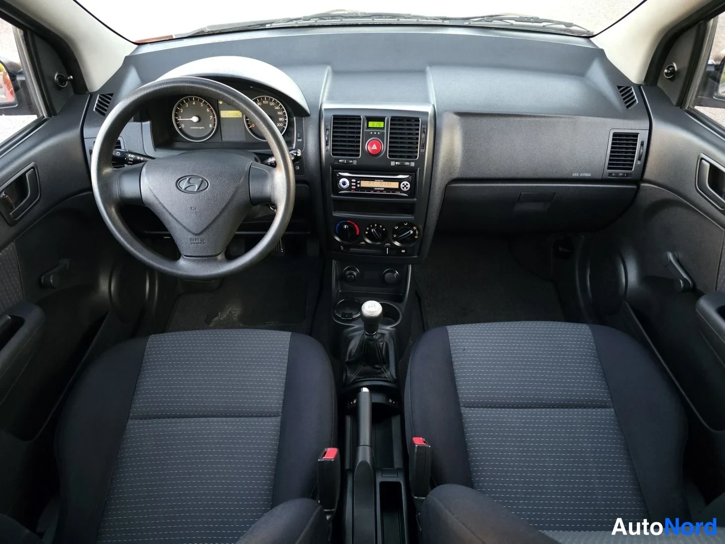 Ohjaamo: Hyundai Getzin etuosa: musta ohjauspyörä, mittaristo ja keskipaneeli manuaalivaihteistolla