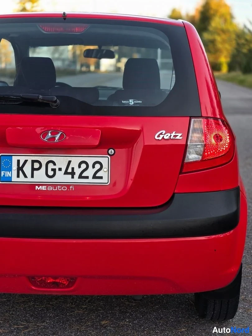 Takaa: Punaisen auton takapää suoraan takaa kuvattuna: takaluukussa Hyundai-logo ja Getz-merkki, alla rekisterikilpi. Takavalot, musta puskuriala ja takalasinpyyhkijä