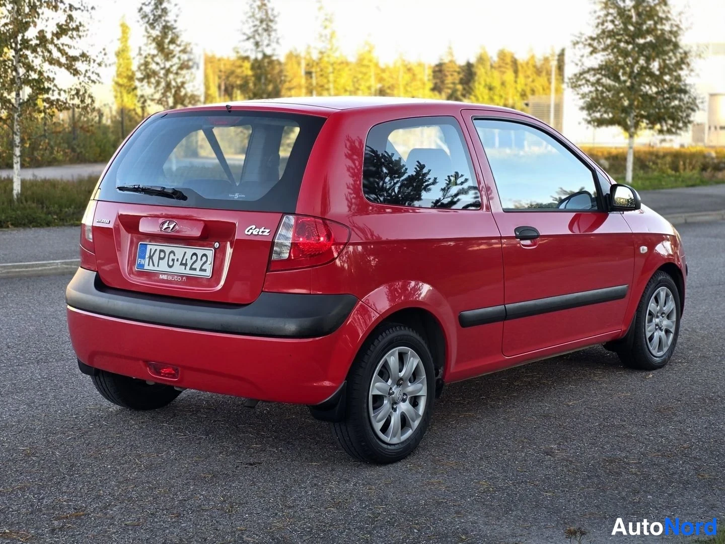 Takaviisto: Punainen Hyundai Getz kuvattuna takaa viistosti; takaluukussa Getz-teksti, Hyundai-merkki ja rekisterikilpi, ovien alaosissa mustat suojalistat.