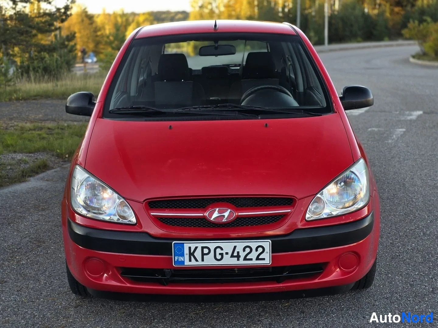 Edestä: Punaisen Hyundai Getzin keula suoraan edestä kuvattuna; etusäleikössä Hyundai-merkki, rekisterikilpi ja musta puskurin alalista.