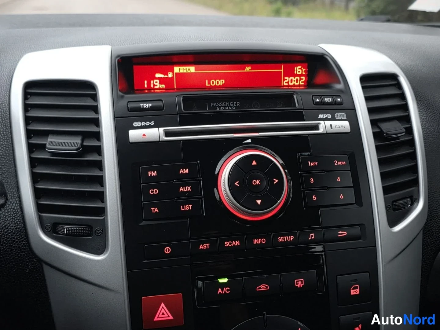 Ohjaamo: Keskitason näyttö ja äänijärjestelmä. Punaisella valaistu digitalinen näyttö osoittaa lämpötilan, ajan, radiokanavan ja ajomatkan 119 km. Painikkeina FM/AM, CD,