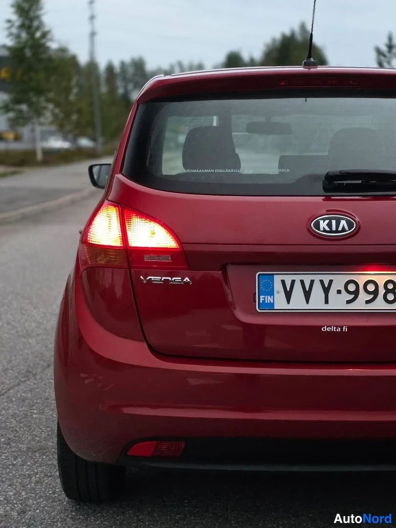 Takaviisto: Autoa takaa ja oikealta viistosta katsottuna; punainen katto ja takaluukku, taivalvalot sytytettynä.
