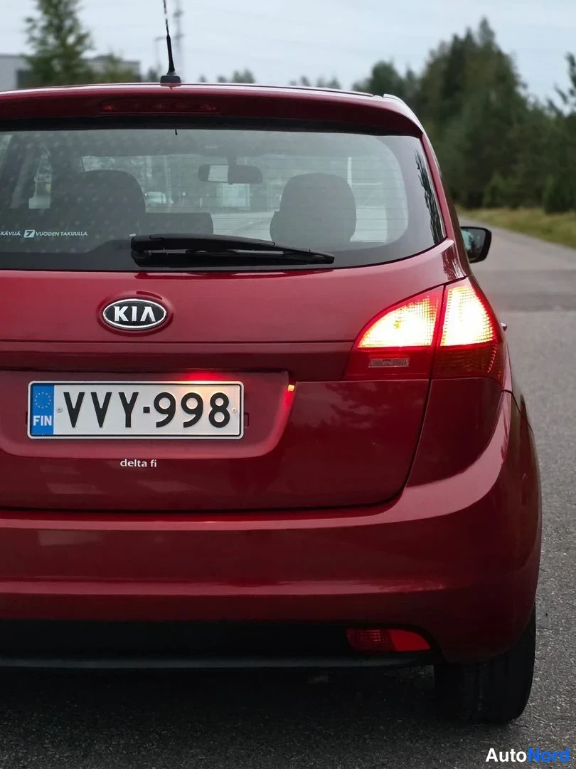 Takaviisto: Autoa takaa ja vasemmalta viistosta katsottuna; punainen katto ja takaluukku, taivalvalot sytytettynä.
