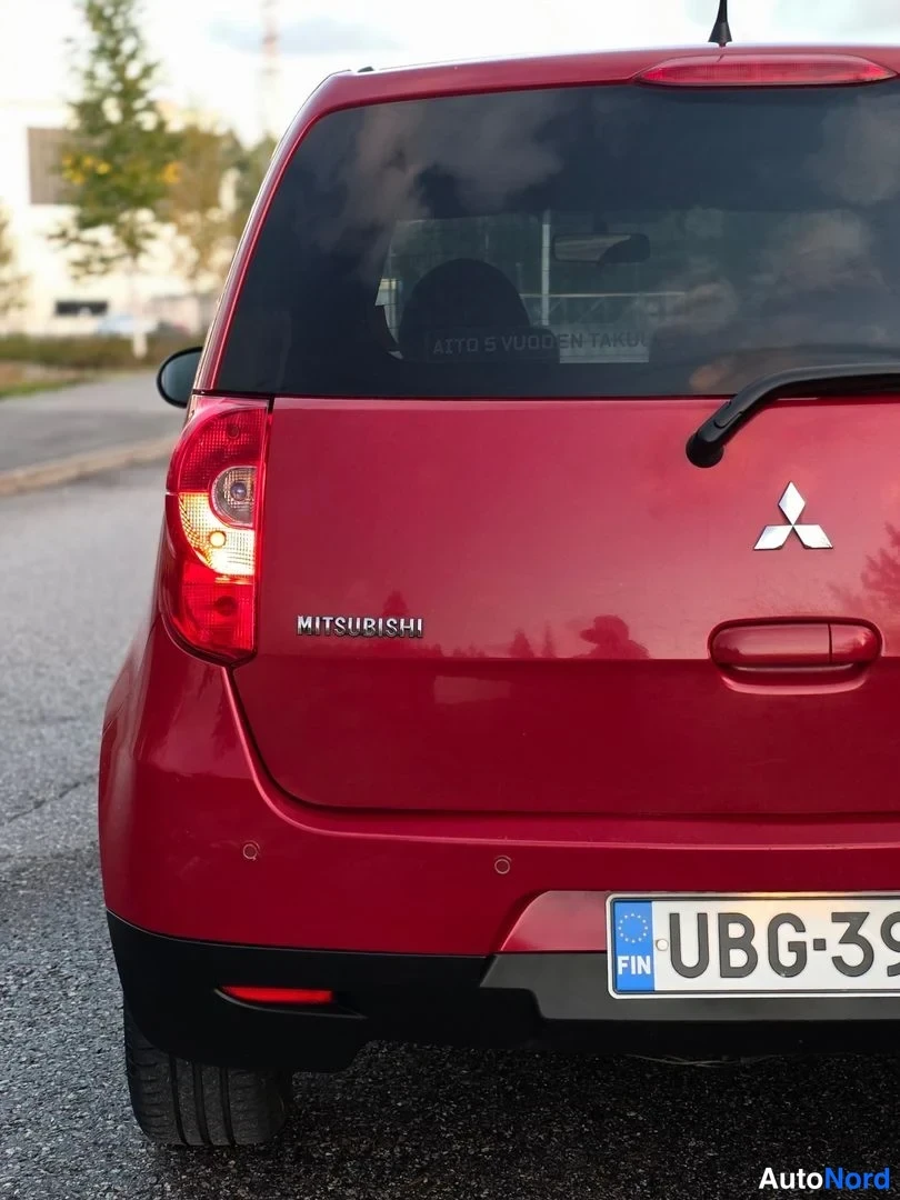 Takaviisto: Auto takaa nähtynä: punainen Mitsubishi Colt -pakettiova, oikea takavalo päällä. Takalaitaan luku ja takaluukussa 'MITSUBISHI'-nimike.