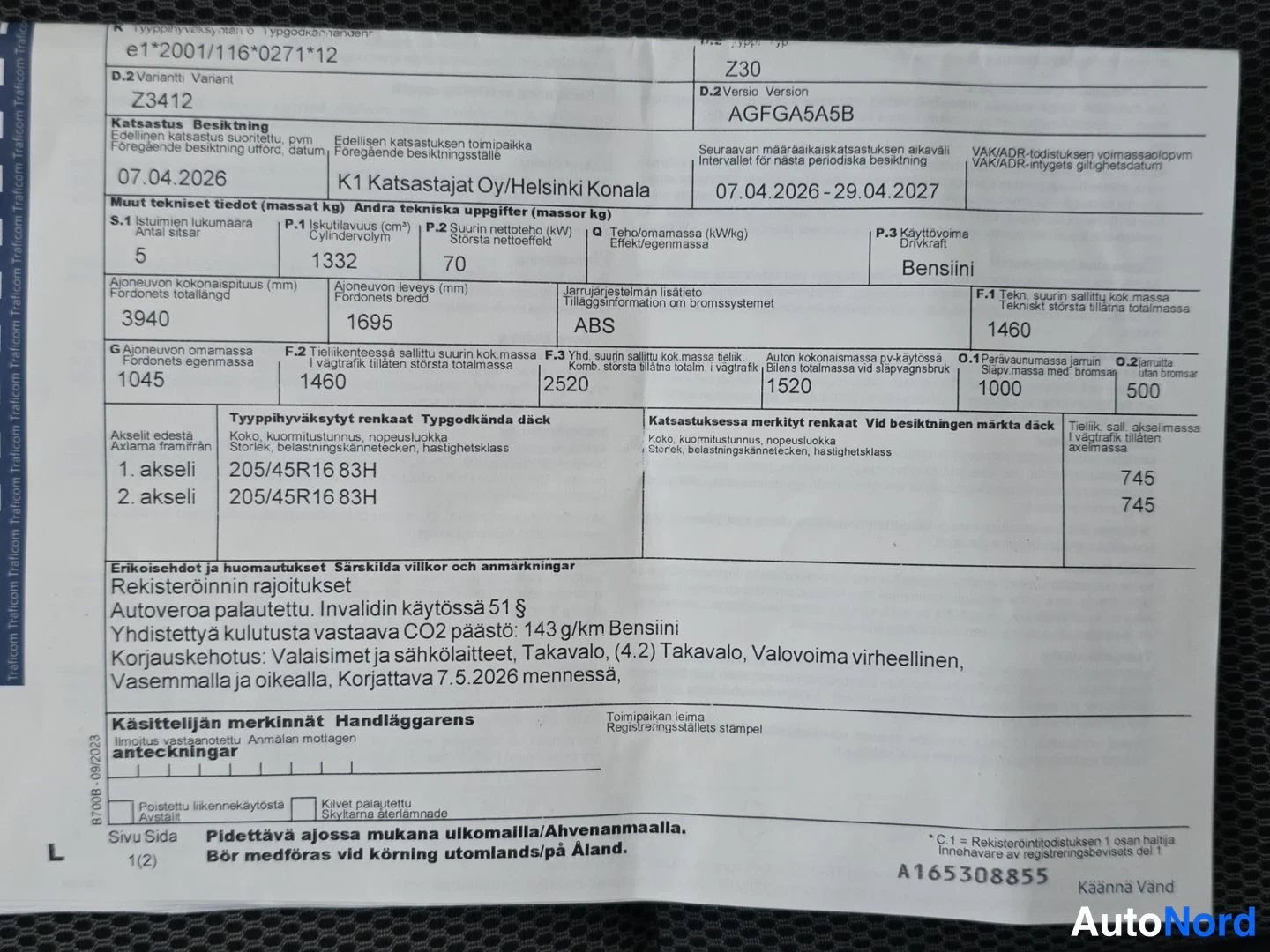 Asiakirja: Finnish vehicle inspection document (Katsastustodistus) on a black carpeted surface showing technical data such as mass in kg, dimensions in mm and tyre sizes.
