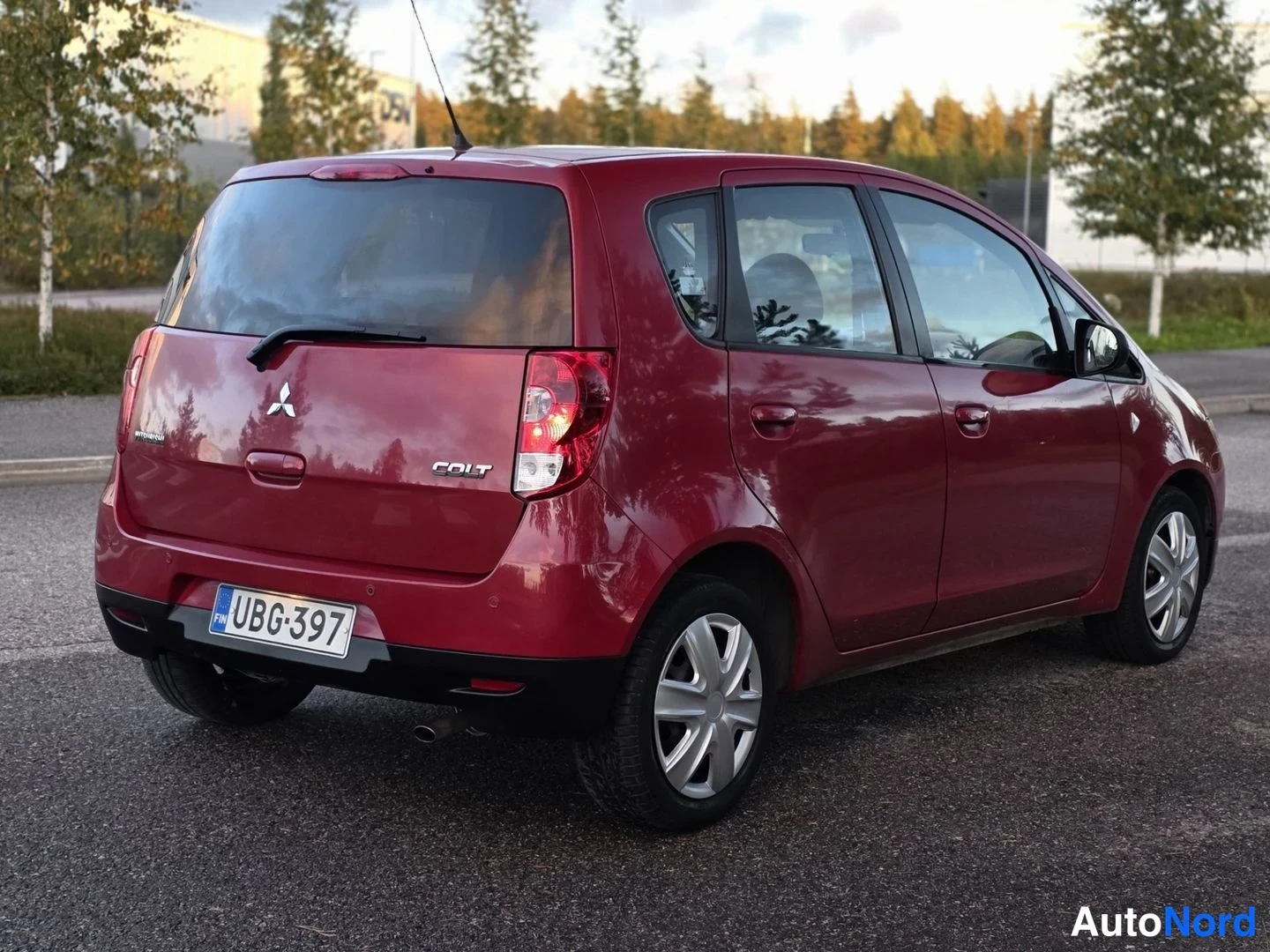 Takaviisto: Mitsubishi Colt -takakolmannes. Punainen auto kuvattuna taaksepäin ja sivusta.