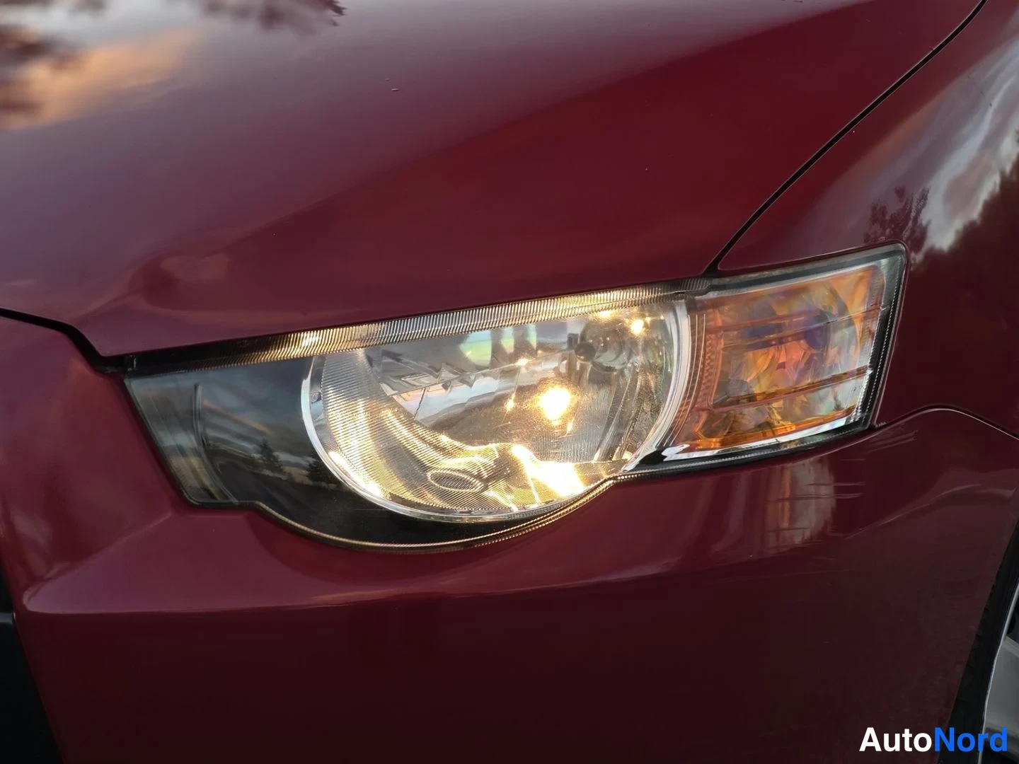 Yksityiskohta: Edessä oleva Mitsubishi Colt-valo -lähikuva. Valon valo syttyy punaiseen korviin.