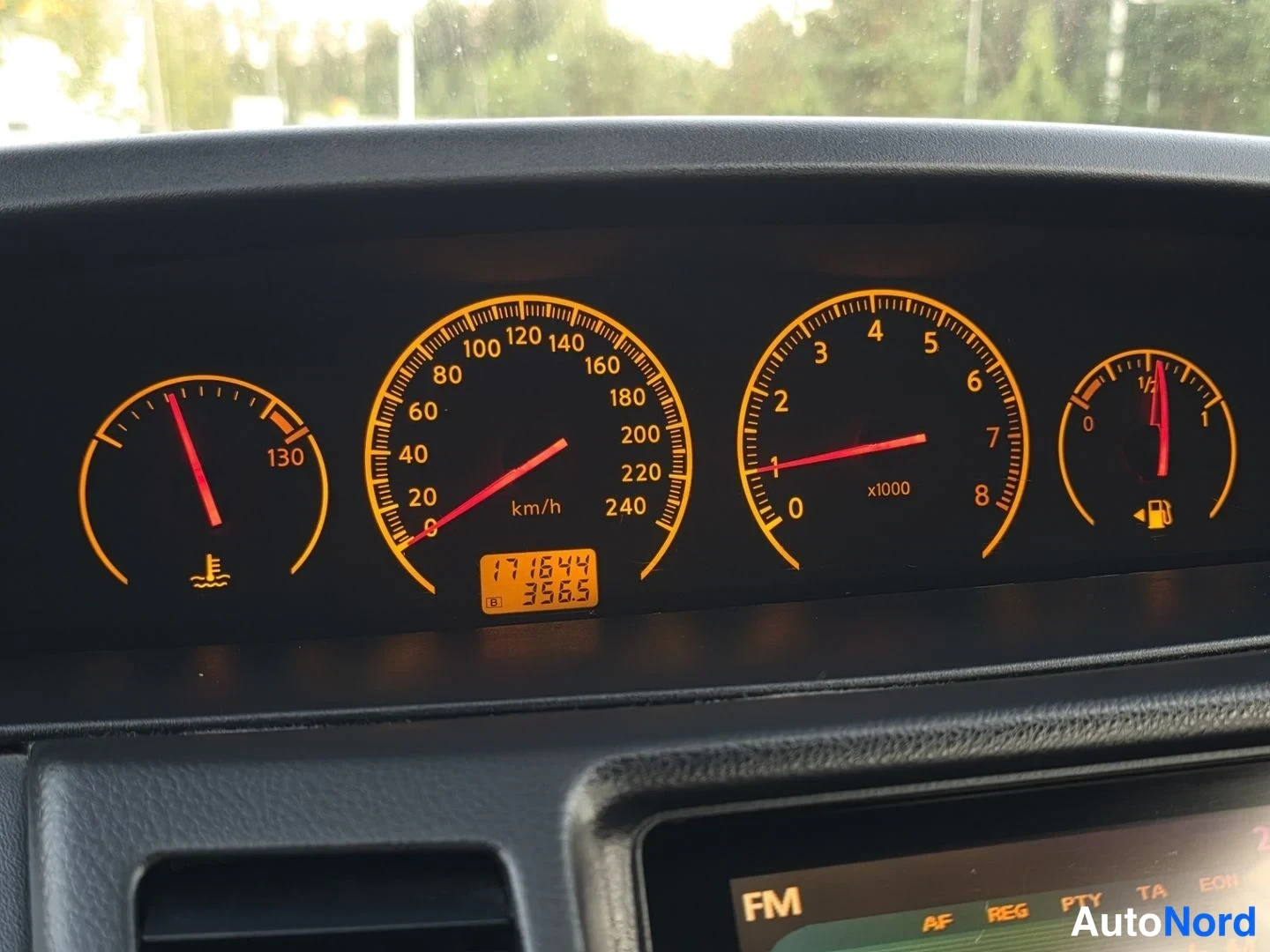 Yksityiskohta: Oranssivalaistu mittaristo: lämpömittari (asteikko 130), nopeusmittari 0–240 km/h, kierrosmittari 0–8 x1000 ja polttoainemittari; LCD-näytössä lukema 171644.