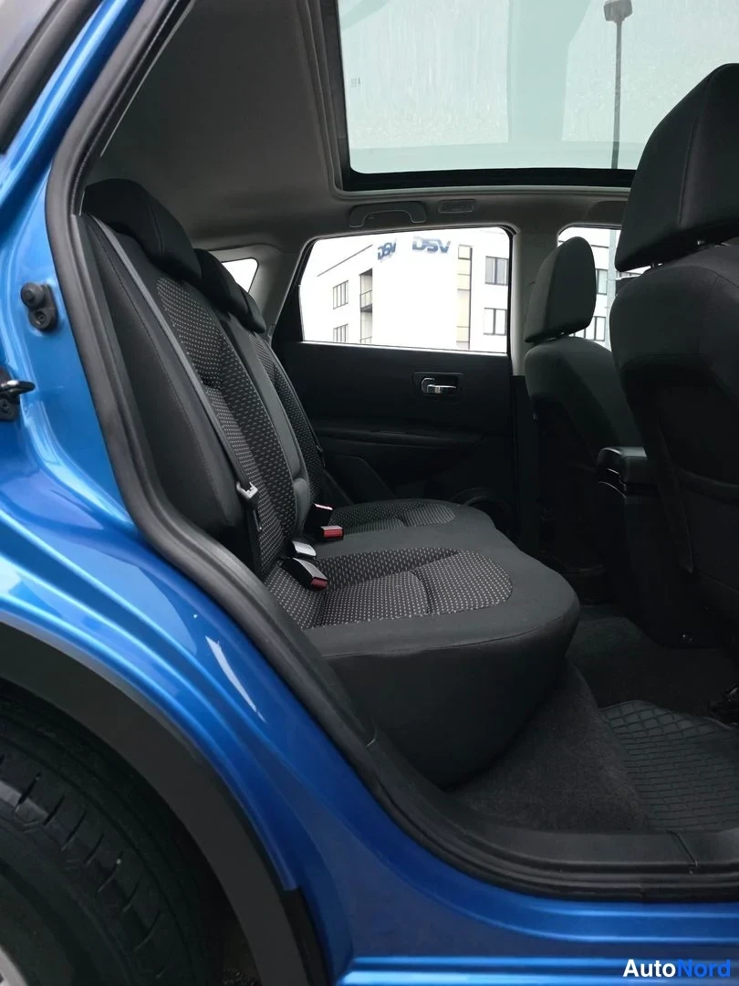 Takaistuimet: Interior view showing two rear passenger seats upholstered in black fabric, viewed through an open rear door frame.