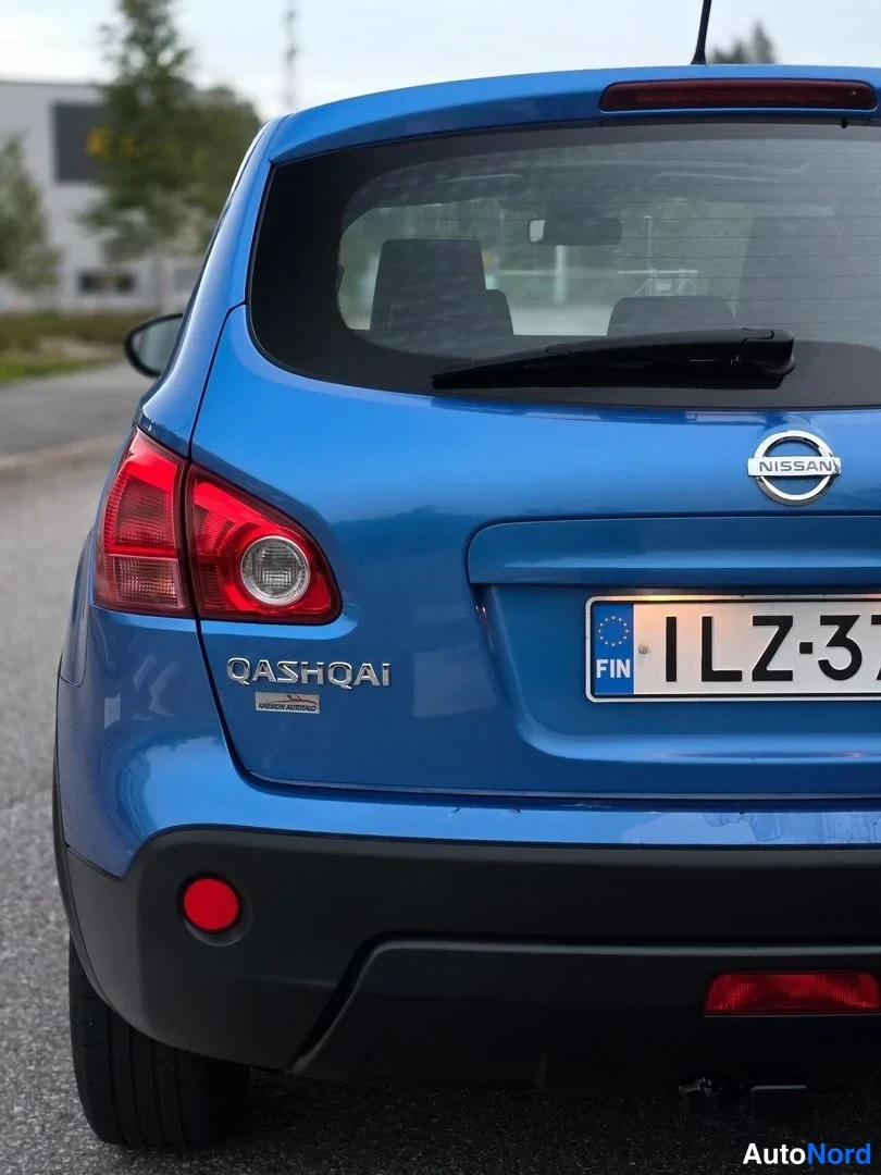 Takaa: Auto: sininen Nissan Qashqai. Takalaituri: taivutusvalot, takavalot, takaluukku, Nissan-logo. Rekisterikilpi: FIN (osittain näkyvä).
