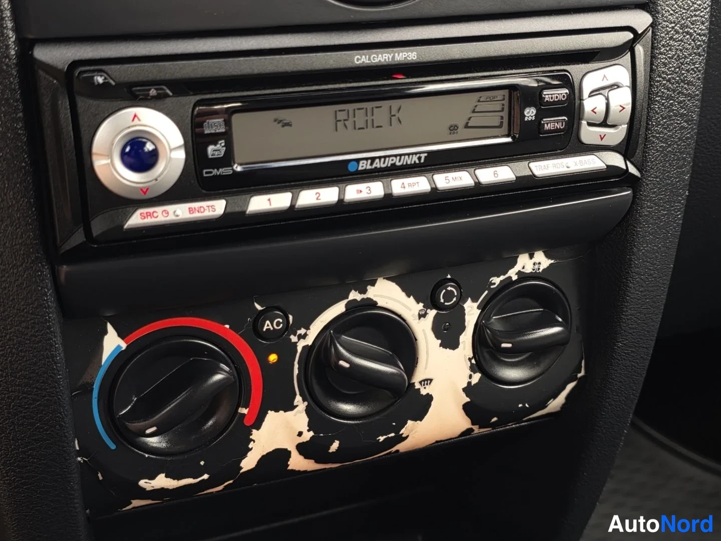 Ohjaamo: Radio on BLAUPUNKT CALGARY MP36 -malli, jossa on näytössä sana ROCK. Radion alla on manuaalisen ilmanvaihdon säätimet, jotka näyttävät kuluneilta ja pilaantunei