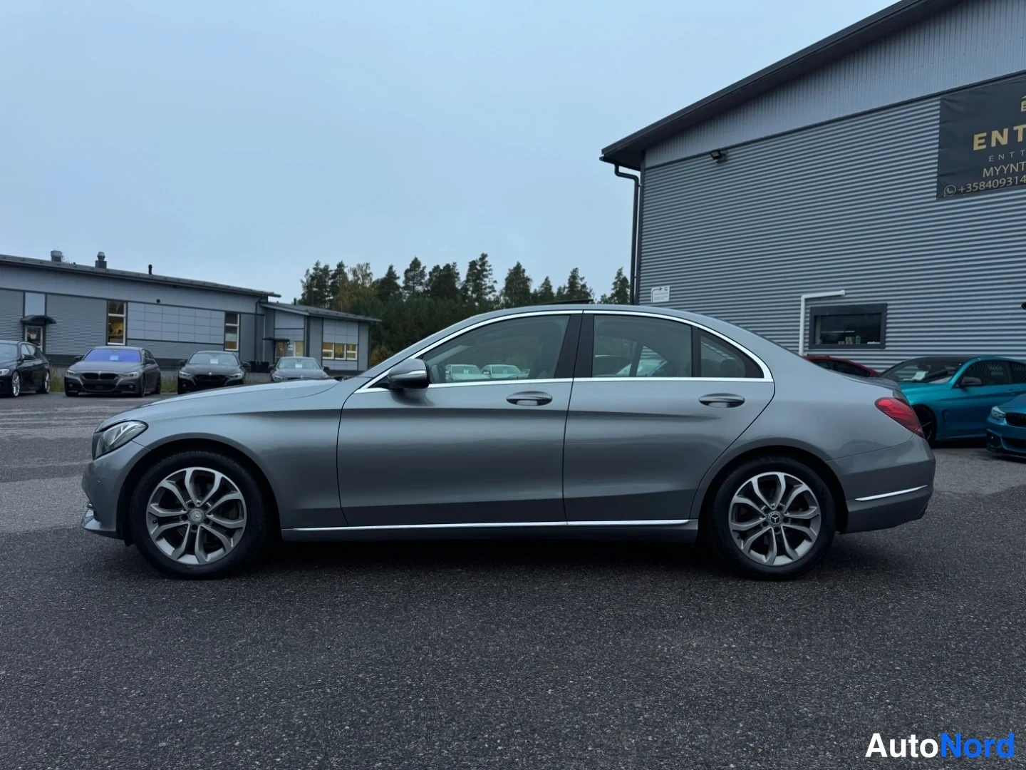 Sivulta: Vasen kokosivunäkymä harmaasta Mercedes-Benz C-sarjan sedanista. Kevennykset, kromipaneelit ja kevytmetallivanteet ovat selkeästi erottuvia.