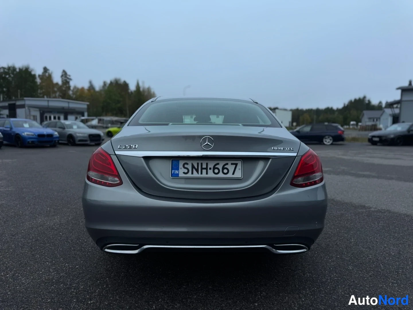 Takaa: Suora takauma harmaanharmaasta Mercedes-Benz-sedanista; peräluukulla Mercedes-tähti, C 220 -merkintä ja rekisteritunnus.