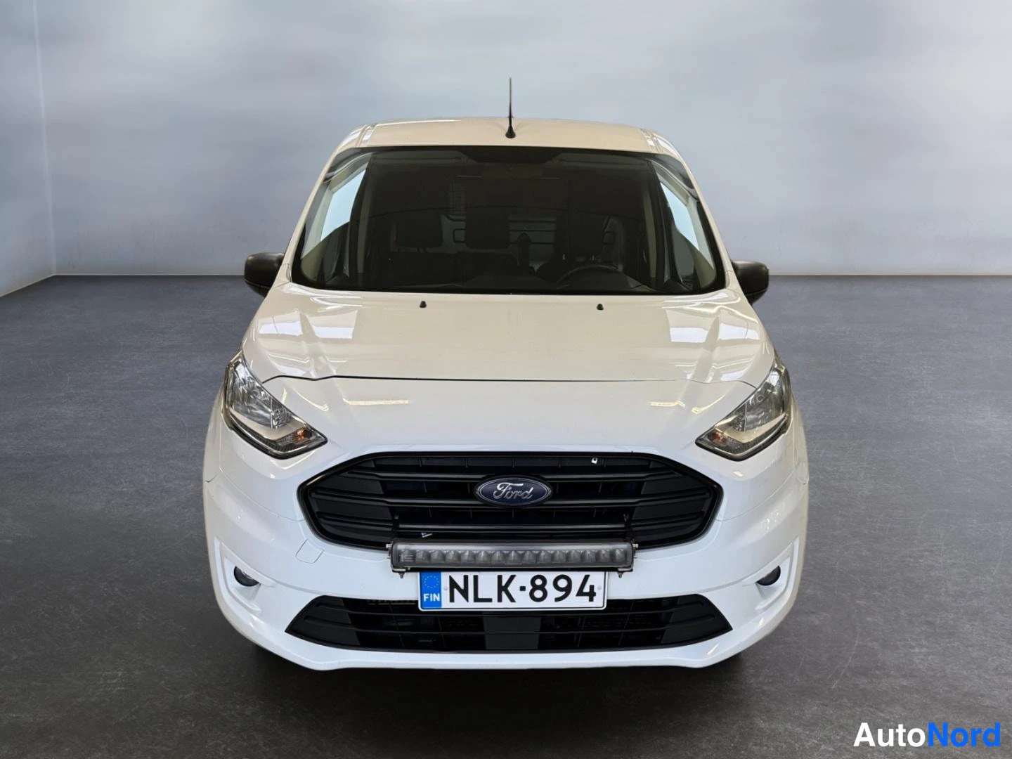 Edestä: Edestä otettu suora kuva valkoisesta Ford Transit Connectista, jossa on lisävalo eturillan yläpuolella.
