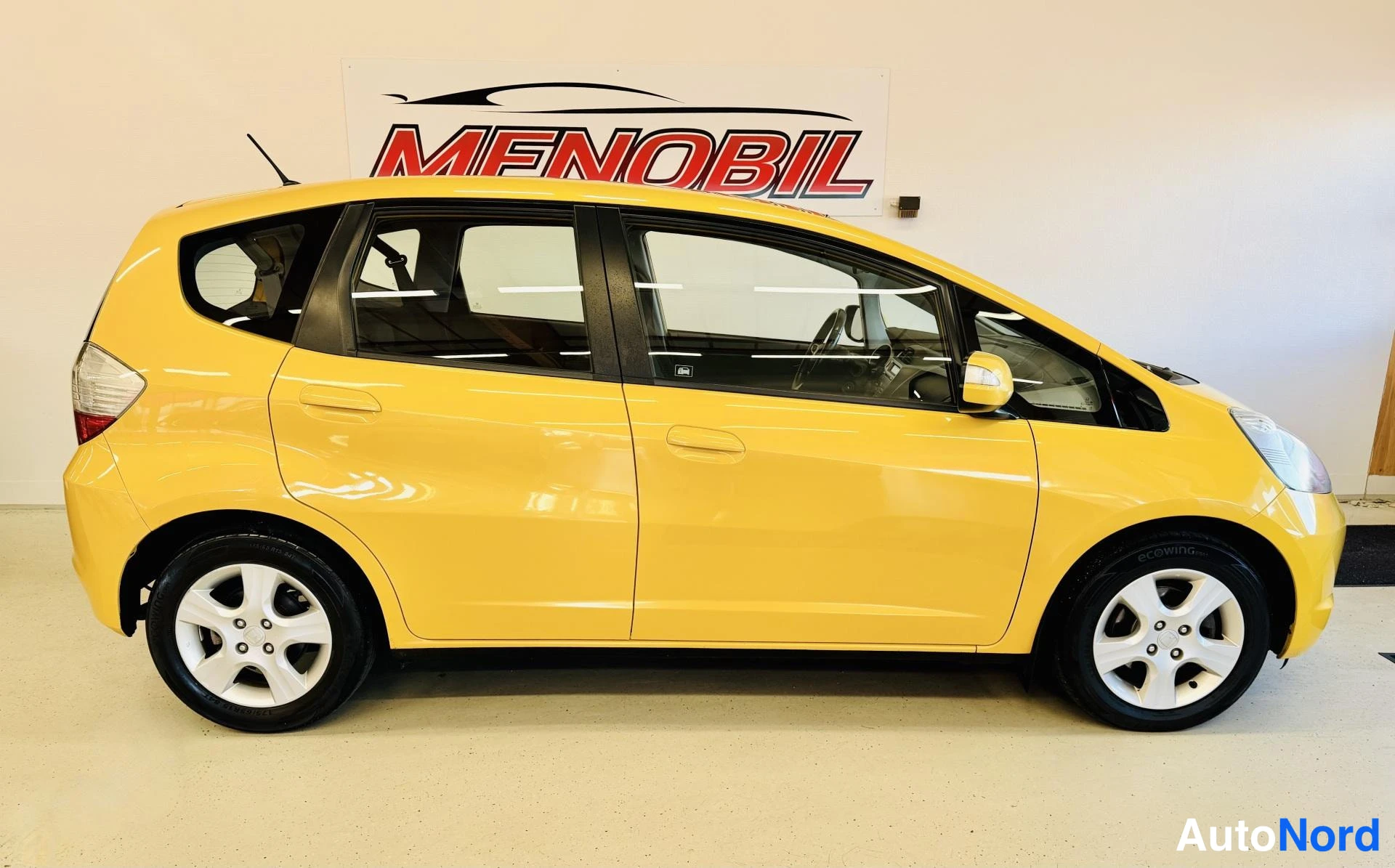 Sivulta: Keltainen Honda Jazz sivulta, oikea kylki näkyvissä.
