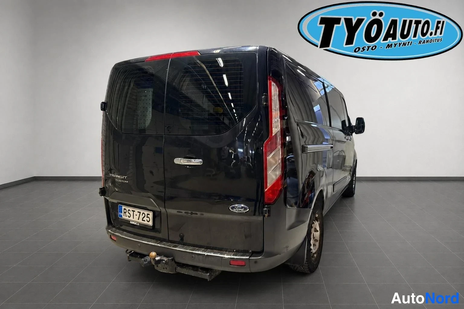 Takaviisto: Ford Transit Custom van from the back right angle. Rear taillights are vertical. A tow hook/bar is visible at the bottom of the rear bumper.
