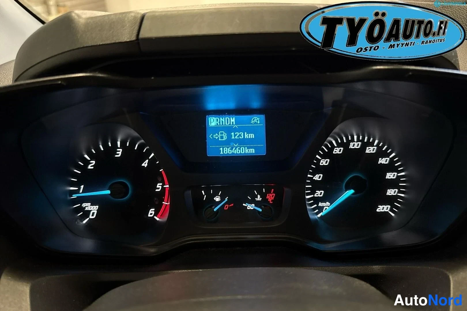 Muu: Ford Transit Customin digitaalinen mittaritaulu, jossa nopeusmittari ja kierroslukumittari. Näytössä lukee 'RNOM', '123 km' ja '186460km'. Mittareiden alapuolel