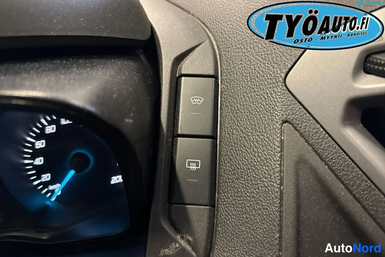 Yksityiskohta: Side of dashboard instrument cluster area with two buttons next to a speedometer showing a windshield wiper symbol for front glass de-icing and a rear window gr
