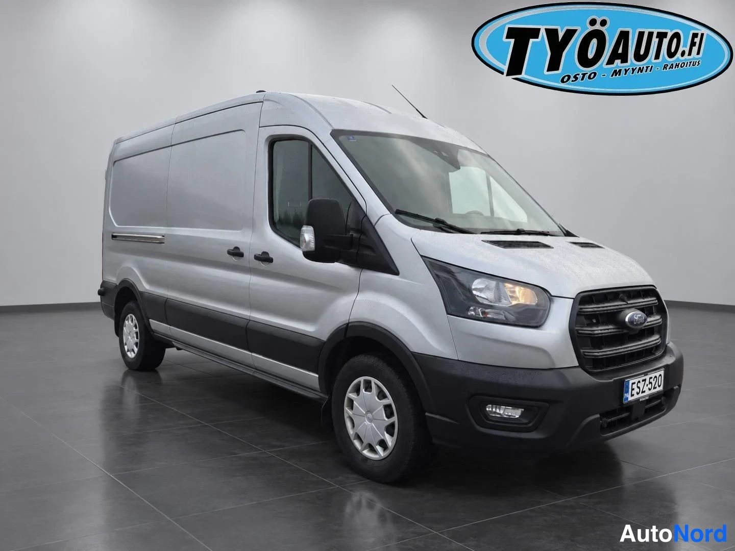 Etuviisto, nokka oikealle: Valkoinen Ford Transit -kuorma-auto etu- ja vasen sivunäkymä sisustuksessa
