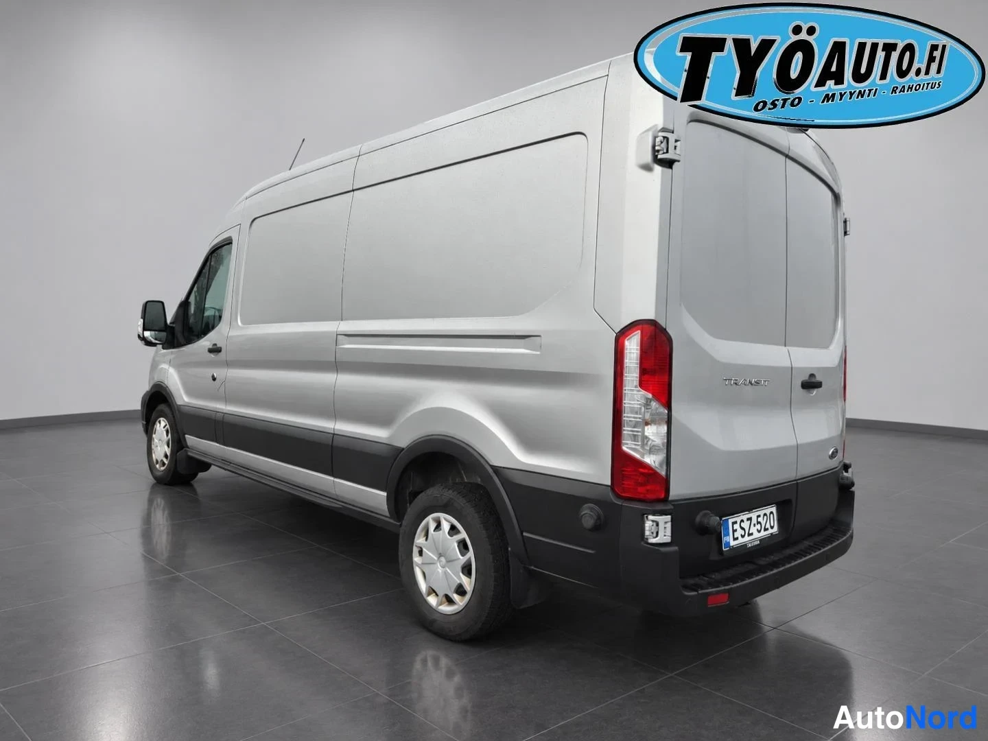 Takaviisto: Silver van photographed from a rear three-quarter angle. Rear bumper has parking sensors. Wheels are steel with hubcaps.