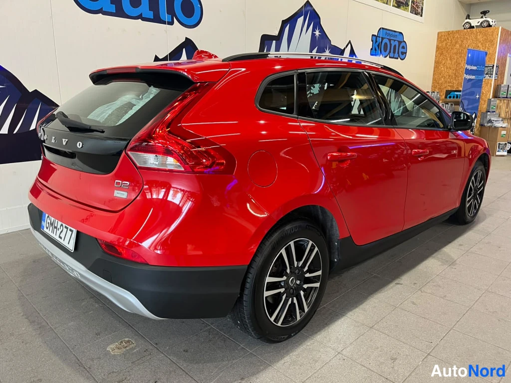Takaviisto: Punaisen Volvo V40:n takakulmanäkymä sisätiloissa, rekisterikilpi, D2-merkintä takaluukussa.