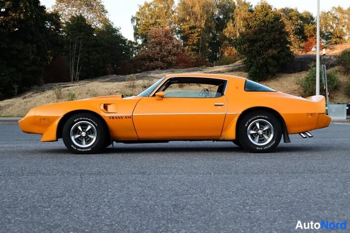 Sivulta: Oranssi urheiluauto sivulta kuvattuna; kyljessä lukee TRANS AM.