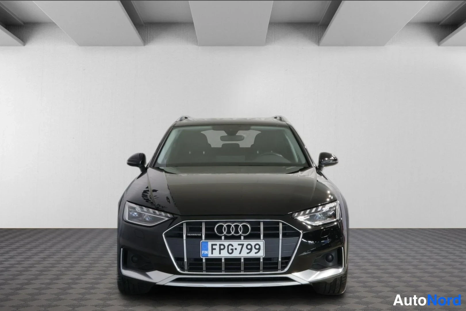 Edestä: Musta Audi A4 Allroad suoraan edestä kuvattuna, etusäleikkö ja Audi-tunnus näkyvissä, rekisterikilpi.