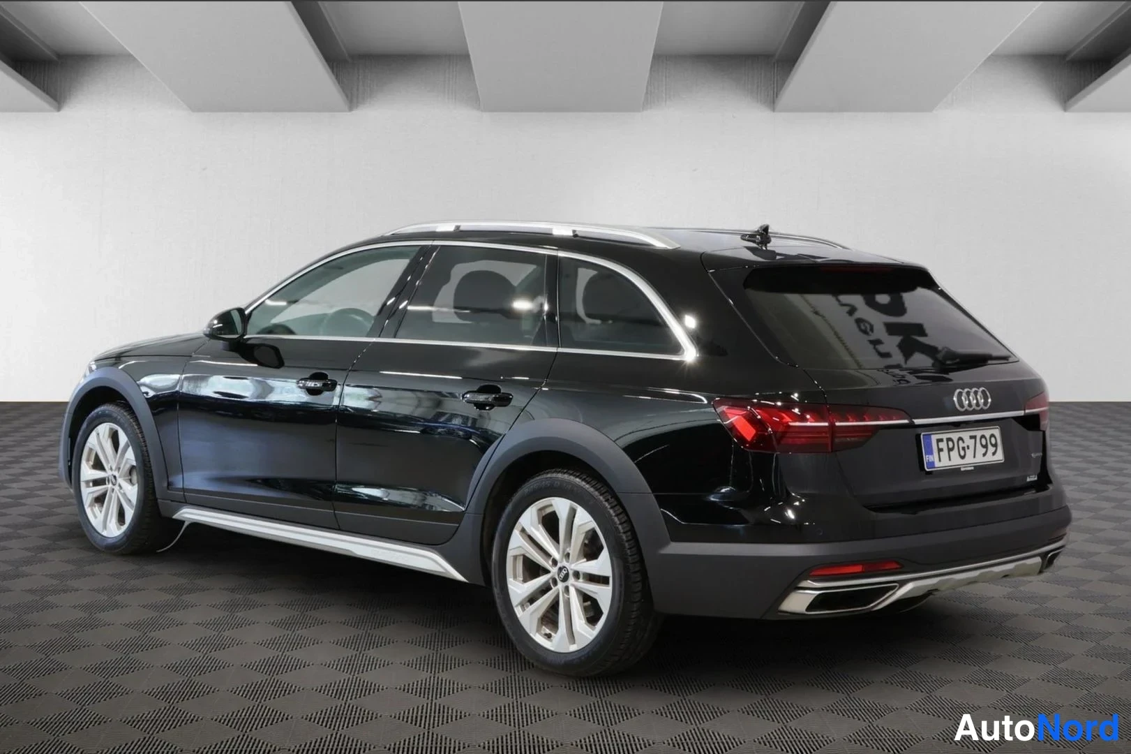 Takaviisto: Musta Audi A4 Allroad takakulmasta vasemmalta kuvattuna, takavalot ja Audi-tunnus näkyvissä, rekisterikilpi.