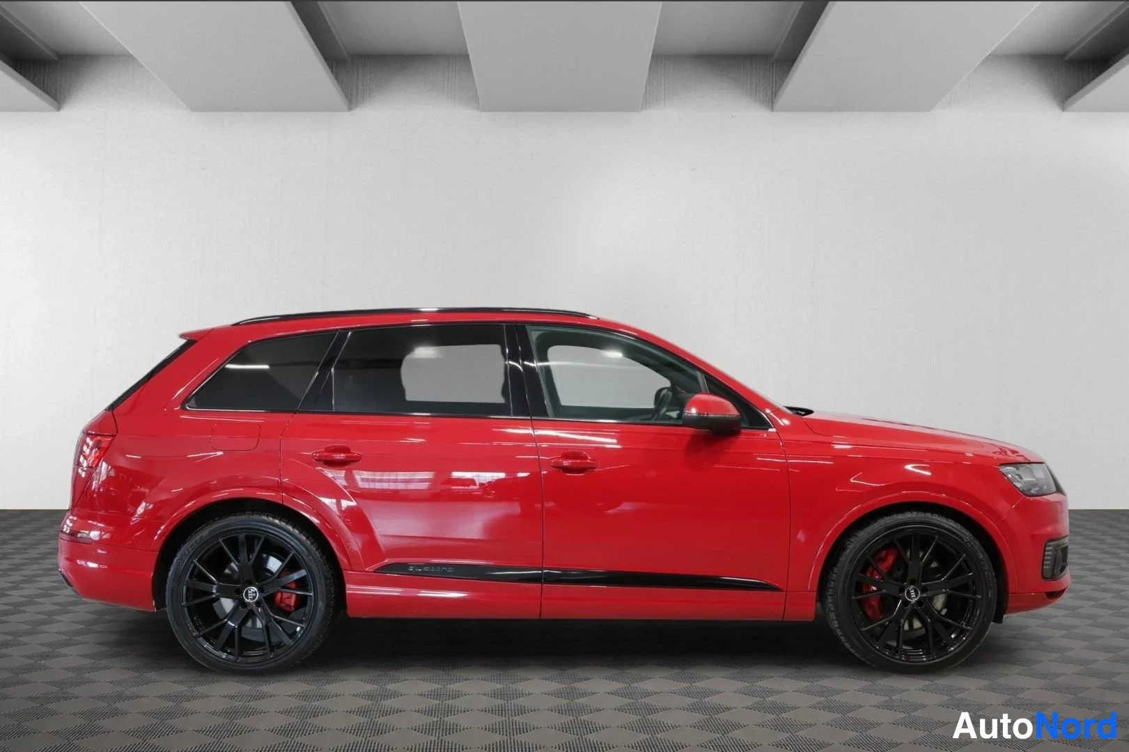 Sivulta: Audi Q7 sivulta, punainen koripaneeli, mustat vanteet ja kromiset ikkunakehykset.