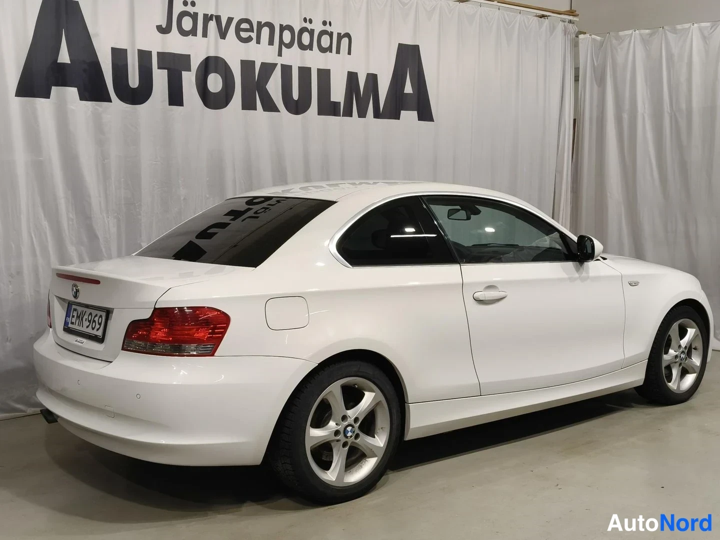 Takaviisto: Valkoinen BMW-kaksoiskupé takakolmasosanäkymässä, punaiset takavalot ja rekisterikilpi näkyvissä.