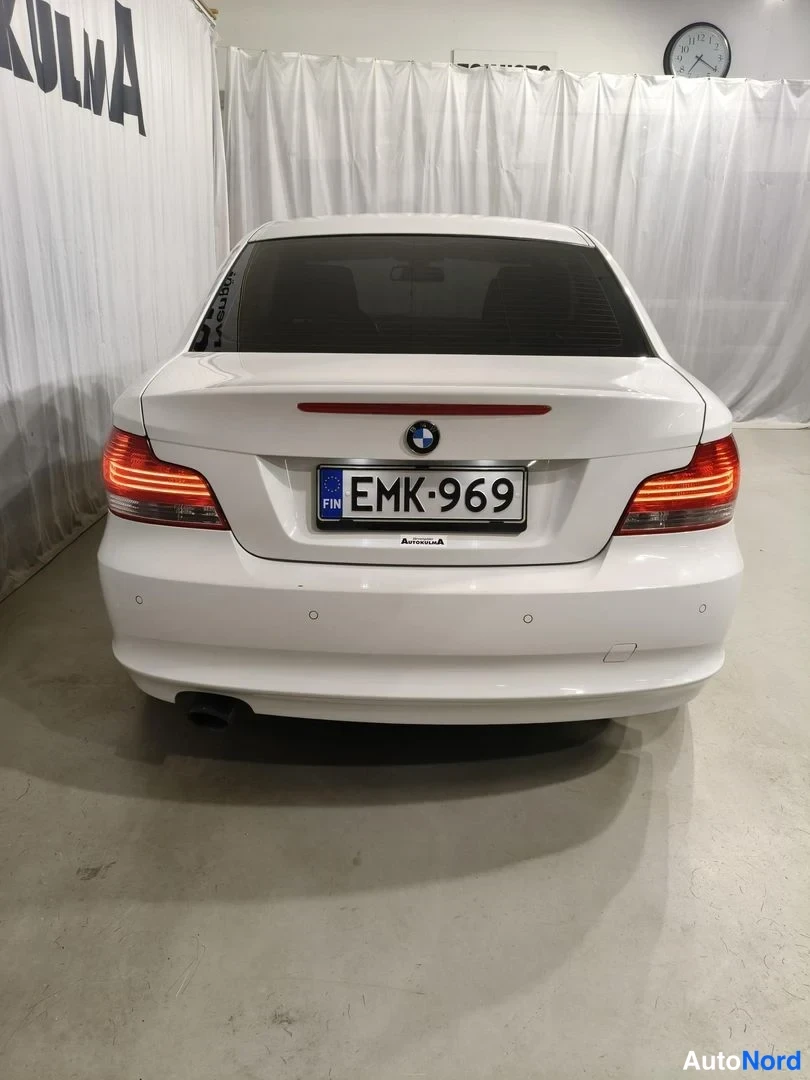Takaa: Valkoisen coupé-auton takaosa suoraan takaa, rekisterikilpi.