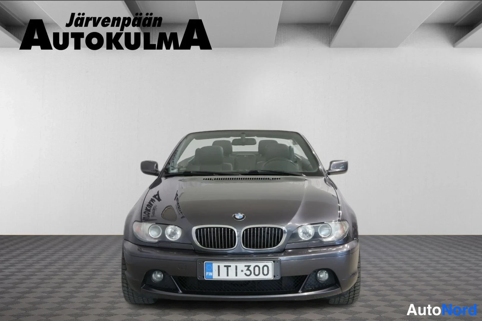 Edestä: BMW 3-sarjan avoauto suoraan edestä kuvattuna, katto auki, rekisterikilpi.