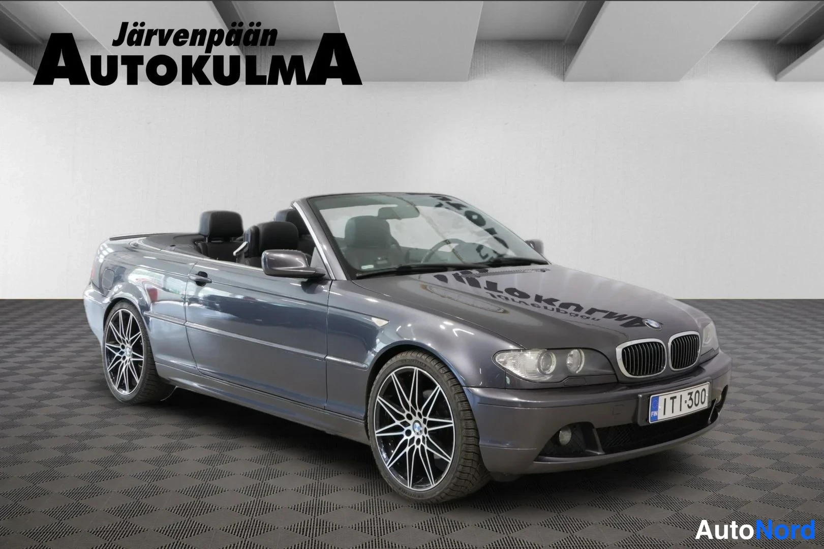Etuviisto, nokka oikealle: BMW 3-sarjan avoauto etuviistosta oikealta kuvattuna, katto auki, harmaa kori.