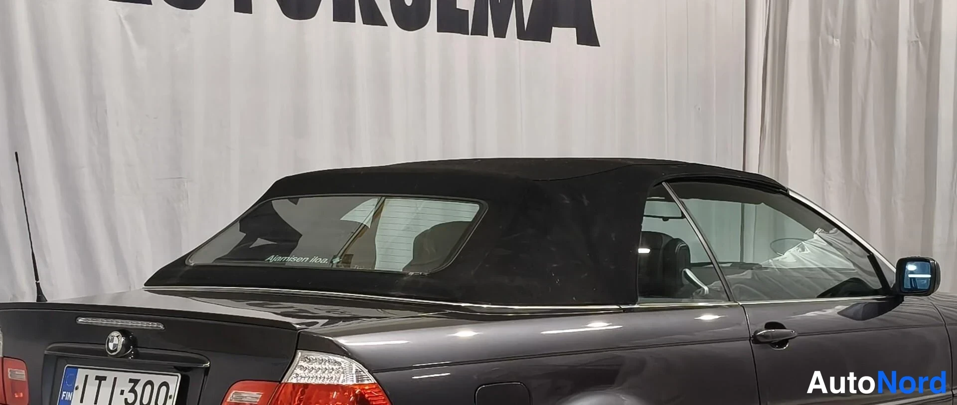 Takaviisto: Kangaskatto nostettuna BMW:n takapäästä ja kyljestä kuvattuna; rekisteritunnus.