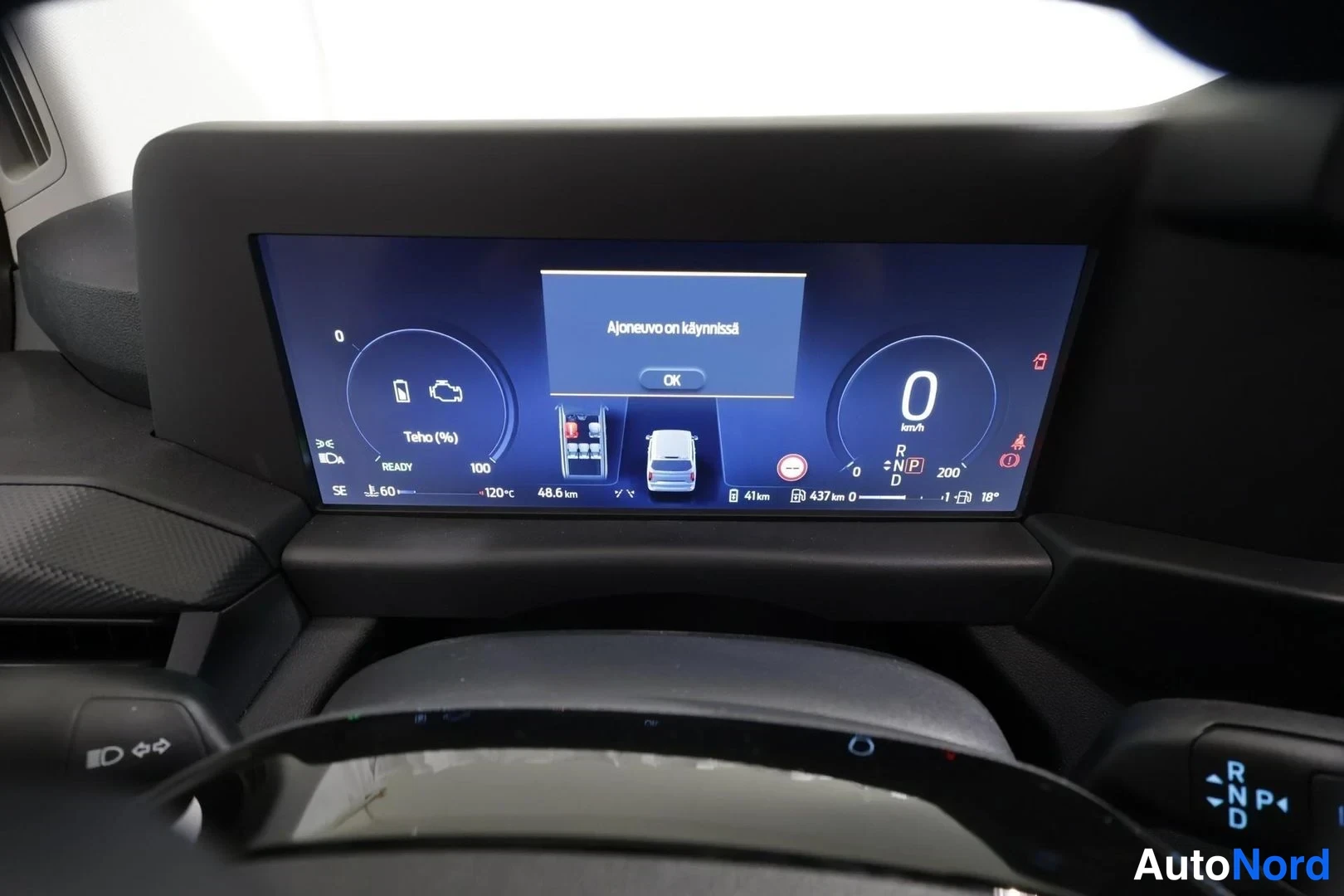 Edestä: Auton kojelaudan infotainment-näyttö ilmoittaa 'Ajoneuvo on käynnissä' -painikkeella OK.