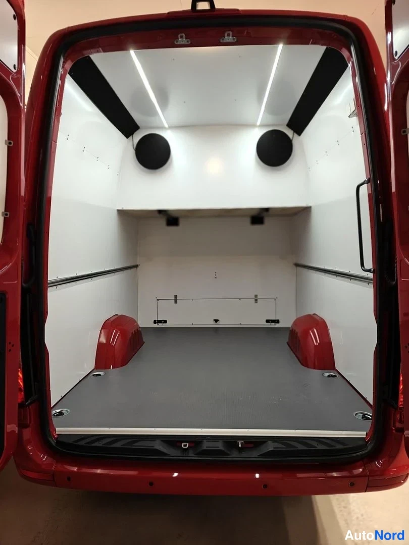 Takaa: Avatun pakettilavan takaoven sisäpuoli: valkoinen, hyväkuntoinen kuormatila, LED-valot, takaa katsottu.