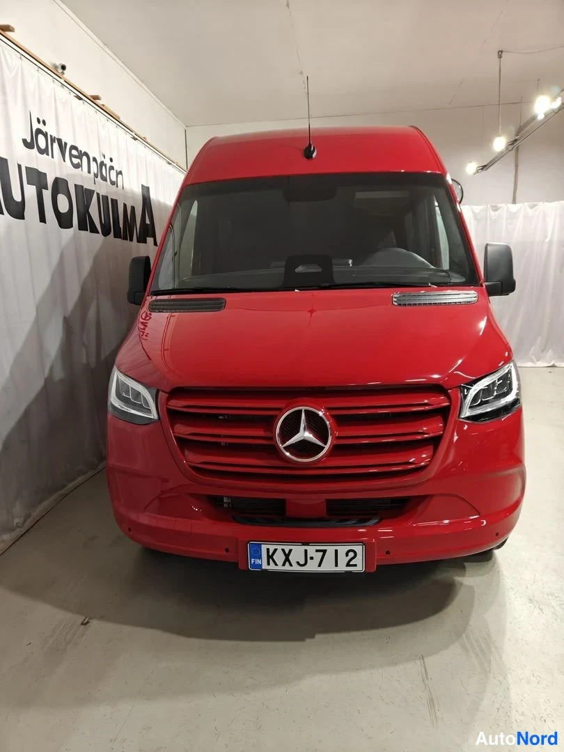 Edestä: Punainen Mercedes-Benz Sprinter -pakettiaivo suoraan edestä, tähtimerkki säleikössä ja rekisterikilpi.