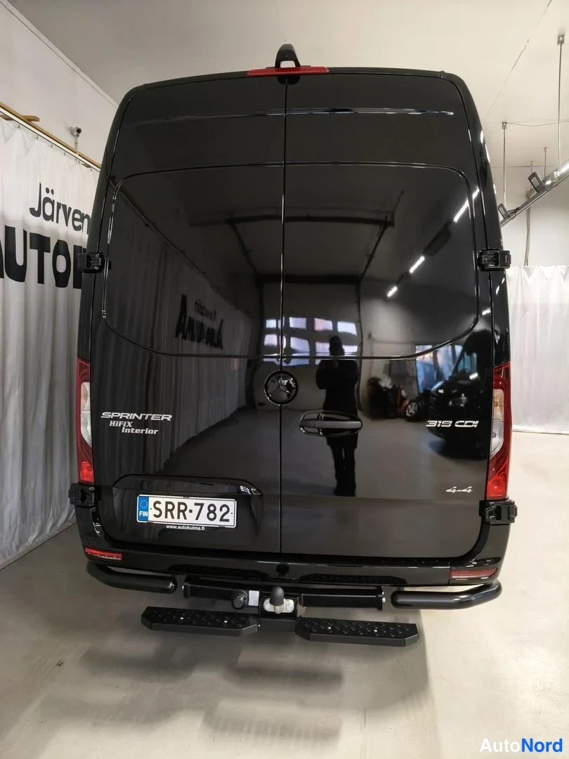 Takaa: Mustan pakettiauton takaosa: takoveto, kaksi takaluukun kahvaa ja rekisteri.