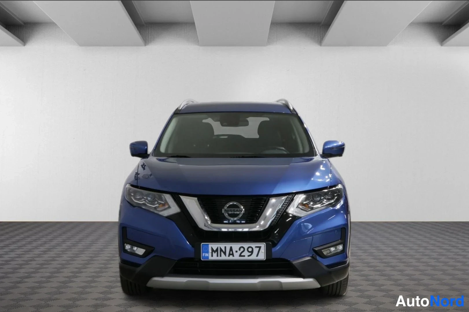 Edestä: Nissan X-Trailin etunäkyvä sininen SUV, Nissan-merkki jäähdyttimen säleikössä ja rekisterikilpi.
