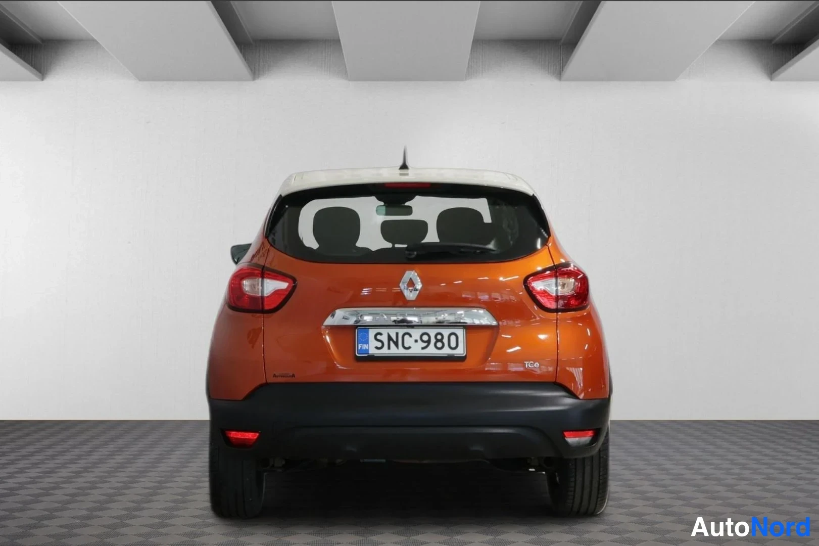 Takaa: Oranssi Renault Captur suoraan takaa, rekisterikilpi ja TCe-merkintä puskurissa.
